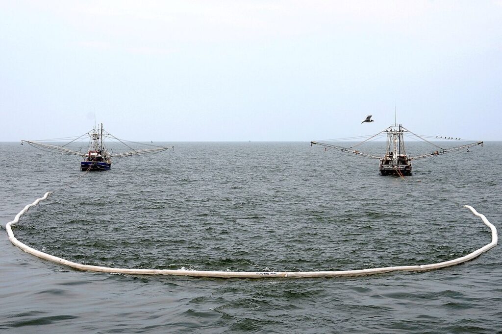 Shrimp boats towing an oil-containment boom in the Gulf of Mexico